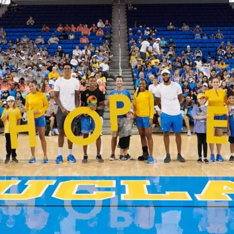A group of people on a basketball court holding letters that spell out hope.