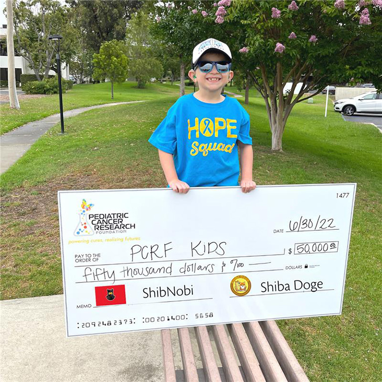 a child holding a donation check to pcrf kids