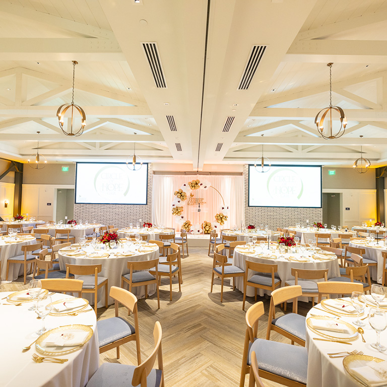 A picture of a ballroom with dining tables set up.