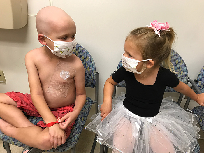 Patients Carter and Tay sitting next to each other with masks on.
